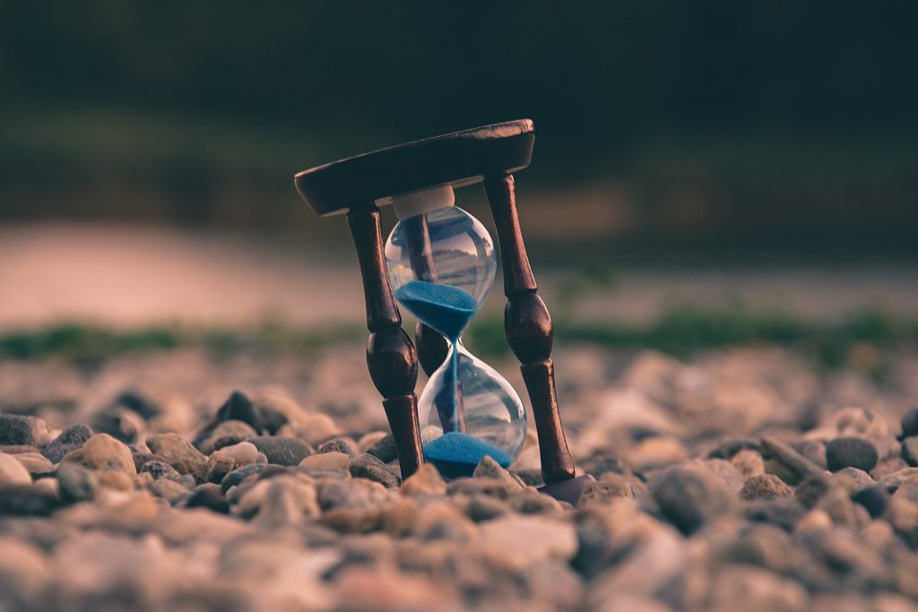A photo of an hourglass in sand.