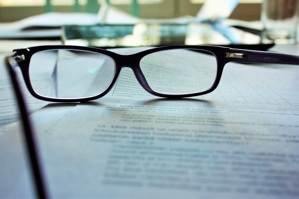 A pair of glasses resting on printed text, representing a reading of the anti-porn laws.