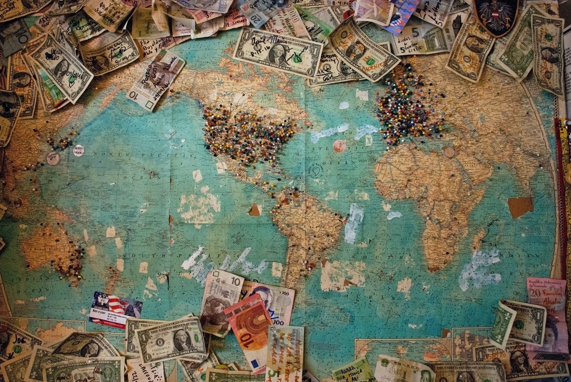 A map of the world, surrounded by currencies from different countries